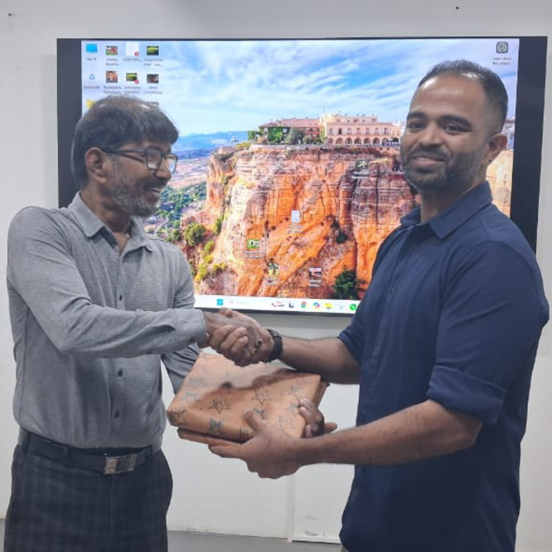 Viswanathan Ganesan from ideas to reach shaking hands and receiving a token of appreciation during an Advertising Club Madras industry event.
