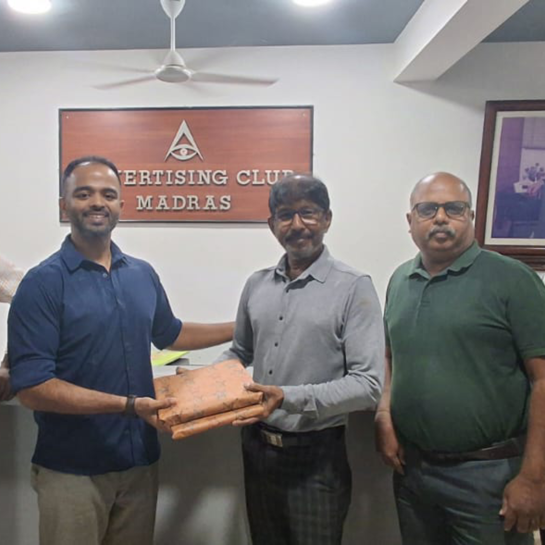 Viswanathan Ganesan of ideas to reach standing with executive committee members in front of the official Advertising Club Madras signage.
