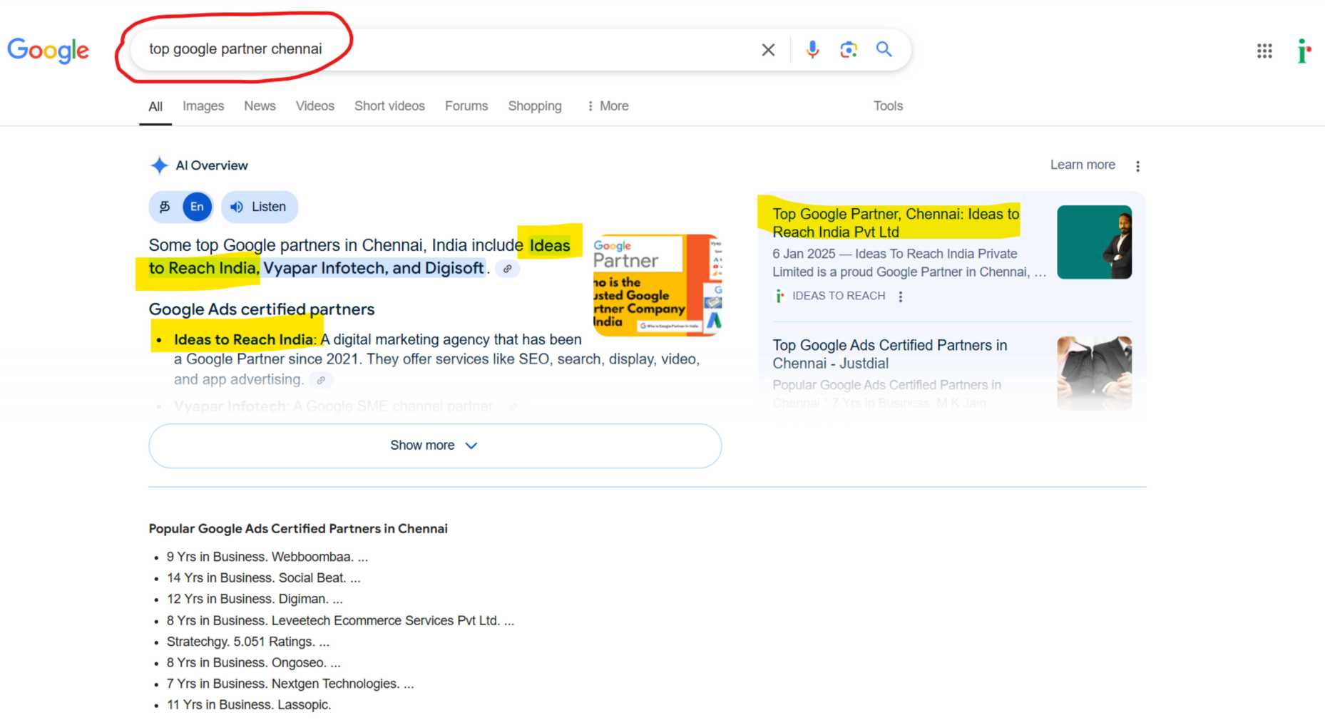 Person using a smartphone to search on Google, with a laptop displaying the Google homepage in the background